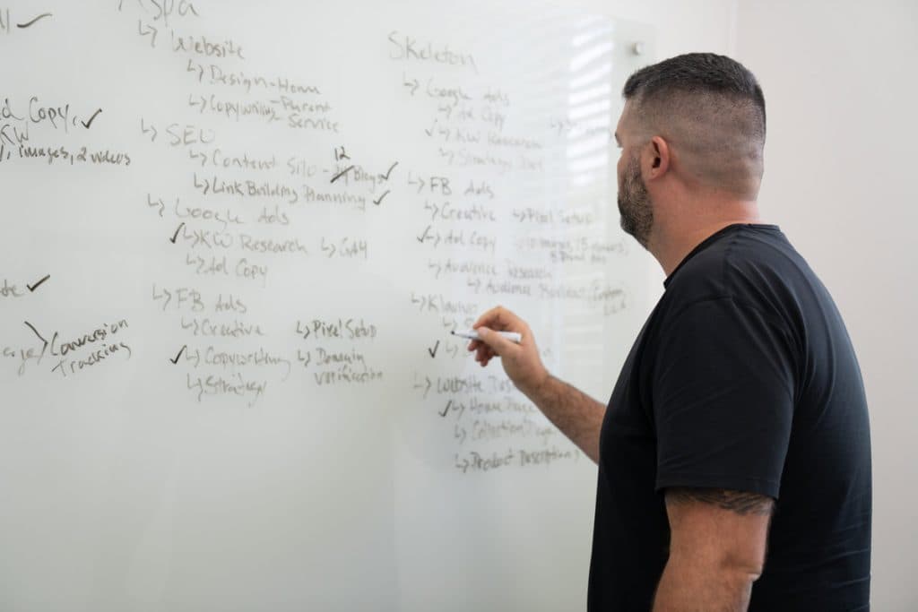 Chris Marrano mapping client strategy at Blue Water Marketing's Stuart, Florida office